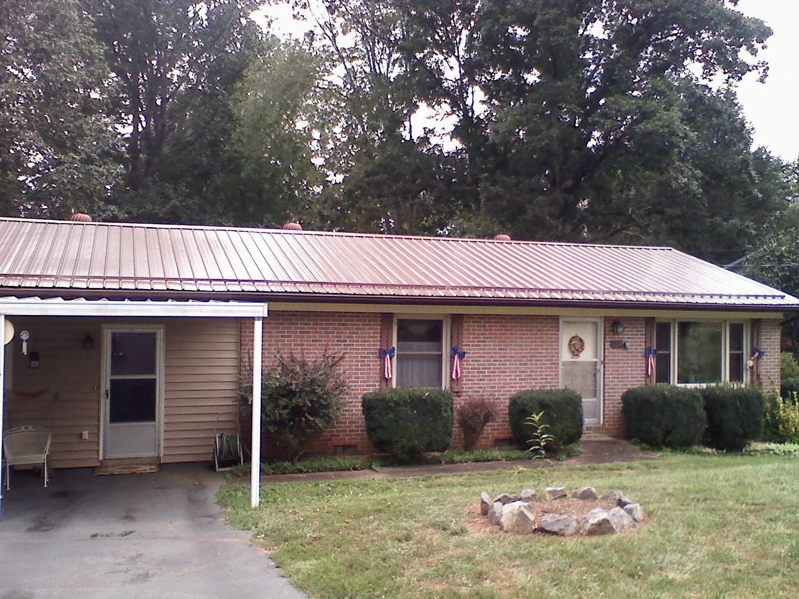 Bronze metal roof and carport on a brick ranch home — Roof Repair work by our crew in Fresno